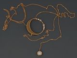 un collier en or orné d'un croissant et d'un pendentif en diamant, monté sur une chaîne