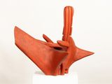 sculpture of a hand holding a piece of wood on a white pedestal