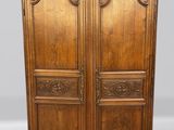 une vieille armoire en bois avec des gravures et des sculptures sur les portes