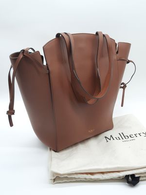 le grand sac fourre-tout en cuir est posé sur un sac en tissu