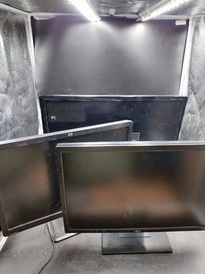 two computer monitors sitting on a stand in a room