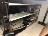 a metal shelf with a television on it in a room
