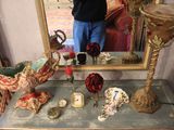 a man taking a picture of a table with a mirror and vases on it