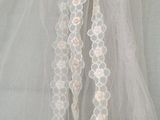 a white veil hanging from a hook on a wall