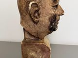 an old wooden head of a man with a mustache on a table