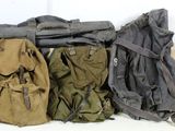 three backpacks are lined up on top of each other on a white surface