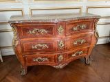a marble top chest of drawers on a wooden floor