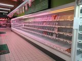 many empty shelves in a grocery store with pink lights