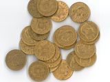 a pile of gold coins sitting on a white surface