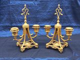 pair of antique brass candelabs on stand on blue cloth