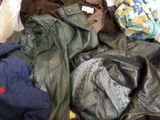 a pile of clothes that is sitting on a bed