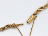a close up of a gold necklace with a chain attached to it