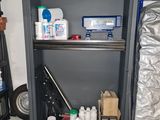 a metal cabinet with several bottles and other items on it