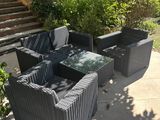 a patio with a table and chairs and a bench