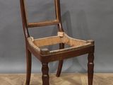 une vieille chaise en bois posée sur un parquet en bois dur