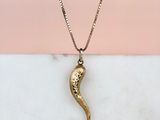 un collier en or avec un pendentif en forme de serpent sur une chaîne