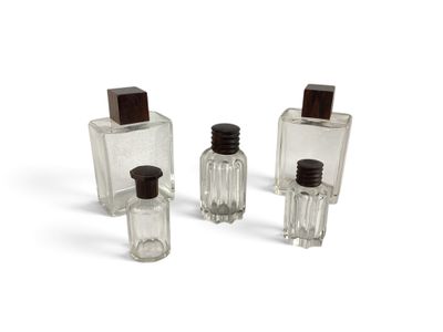 trois bouteilles en verre transparent avec des bouchons noirs et un bouchon en bois brun