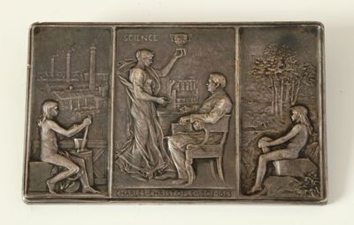 une plaque métallique sur laquelle figurent une femme et deux hommes