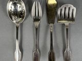 three spoons, a fork, and a spoon rest on a table