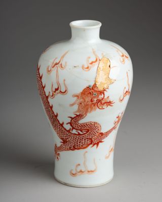 a white and orange vase with a dragon on it
