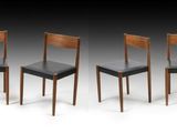 quatre chaises en bois avec des assises en cuir noir, alignées en rangée