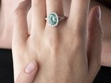 quelqu'un porte une bague sertie d'une pierre verte