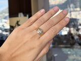 a woman ' s hand that is holding a ring in front of a window