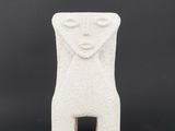 a white ceramic sculpture of a woman ' s face on a black background