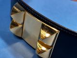 a close up of a black and gold belt on a blue surface