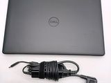 dell laptop computer with power cord plugged into the back of the laptop