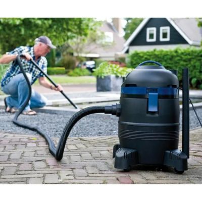 un homme en train de nettoyer une allée à l'aide d'un aspirateur