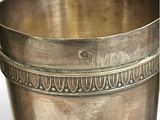 an old silver cup with a decorative design on a white background