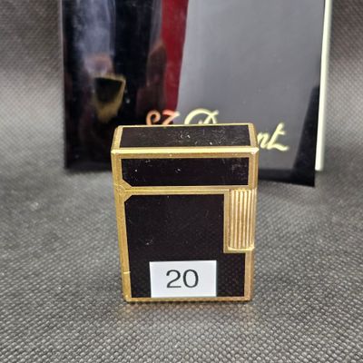 une petite boîte noire et dorée sur laquelle figure le chiffre 20