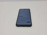 the back of a black phone sitting on top of a white table