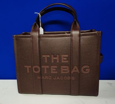 a brown tote bag sitting on top of a white table