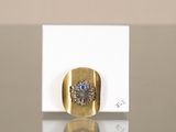 a gold ring with a blue stone on it