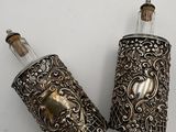 pair of antique silverplated glass perfume bottles with a skull on the top