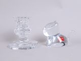 two glass candlesticks and a glass candle holder on a table