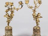 paire de bougeoirs anciens en laiton, ornés de chérubins et de fleurs, sur des socles en marbre