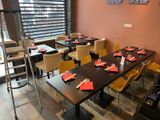 many tables and chairs in this restaurant with red napkins on them