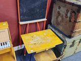 un petit bureau et une chaise dans une salle équipée d'un tableau noir