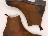 un gros plan sur une paire de bottes marron sur fond blanc