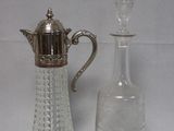 une petite bouteille en verre à côté d'une petite carafe en verre