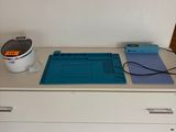 une commode blanche sur laquelle est posé un tapis de découpe bleu