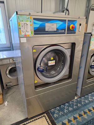 une machine à laver et un sèche-linge dans une pièce dont le sol est recouvert d'un tapis