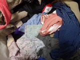 a pile of clothes sitting on top of a bed
