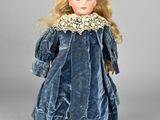 a close up of a doll wearing a blue dress and hat