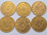 six gold sovereigns of different sizes and shapes