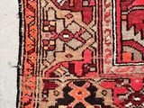 an image of a red and brown rug on a white floor