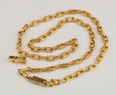 a close up of a gold chain on a white surface